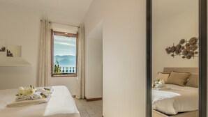 Ein Hotelzimmer mit zwei Betten, einem Fenster mit Bergblick und einer dekorativen Wandarbeit.