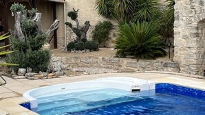 A swimming pool with a hot tub, surrounded by stone walls and various plants. - Le Cabanon (Portel-des-Corbières)