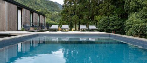 A swimming pool with a view of a mountain and trees.