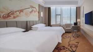 A hotel room with two beds, a desk, a chair, a TV, and a large window. - Changtai Jinbang International Hotel (Zhangzhou)