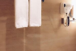 A bathroom with a towel rack, a hairdryer, and a wall-mounted hand dryer. - Changtai Jinbang International Hotel (Zhangzhou)