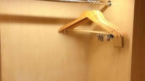 A wooden hanger on a wall-mounted rack with a metal hook. - Changtai Jinbang International Hotel (Zhangzhou)