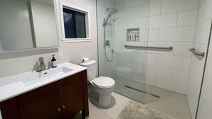 Une salle de bain moderne avec une douche à parois de verre, un lavabo blanc et des toilettes.