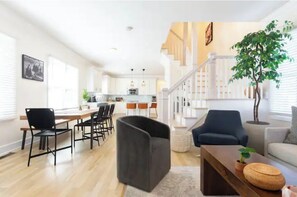 Relax in this stylish living area with a sofa, armchair, and dining table, perfect for socializing and unwinding.