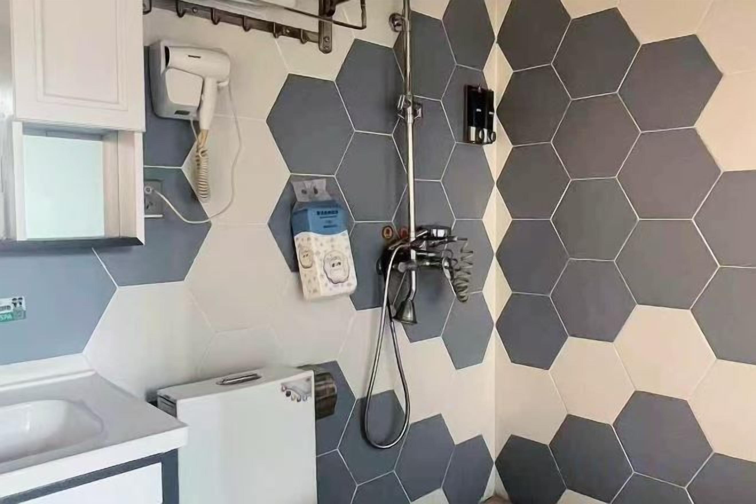 Un baño con diseño moderno, que incluye una ducha, un inodoro y un lavabo.