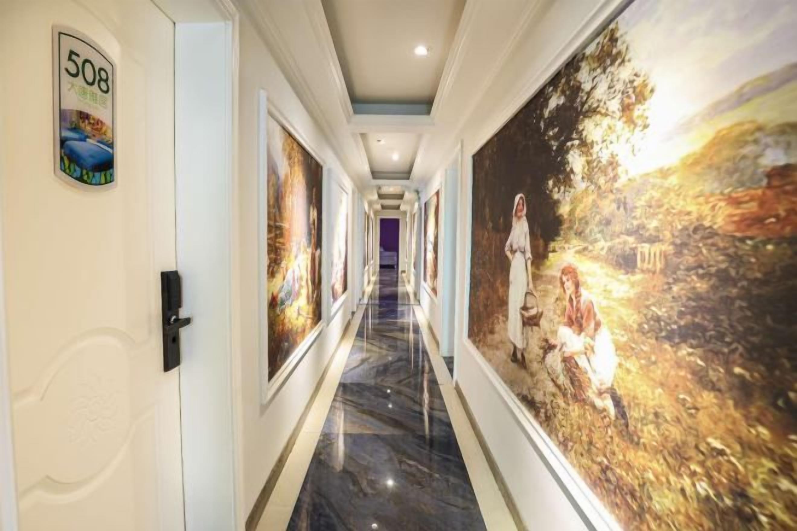 A hallway with a number sign, framed artwork, and a large mural.