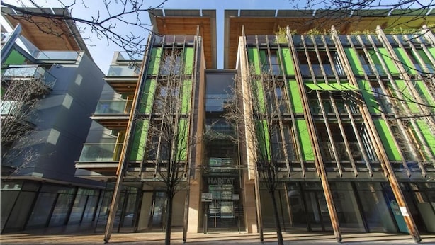 A modern building with a glass facade and vertical wooden slats. - Habitat Apartments (Trento)