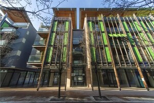 A modern building with a glass facade and vertical wooden slats.
