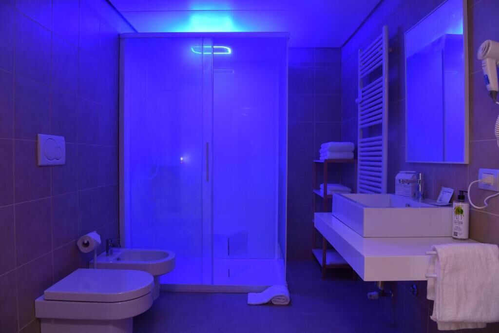 A modern bathroom with a shower, toilet, and vanity.