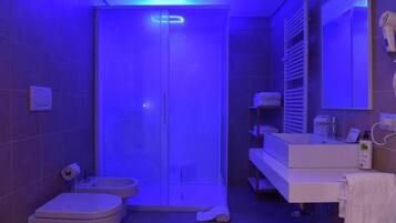 A modern bathroom with a shower, toilet, and vanity.