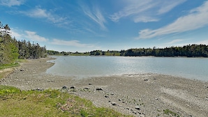 A lakeside view with a rocky shoreline, trees, and a clear sky. - Nest On Mount Desert Isle w Beach - 8 Mi to Acadia (Mt Desert)