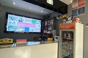 A reception area with a digital display, a refrigerated beverage dispenser, and a cash register. - 100 Inn (Wuhan Optics Valley Geoscience University) (Wuhan)