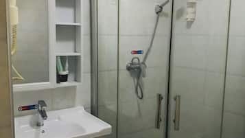 A bathroom with a white sink, a mirror, and a glass shower enclosure.