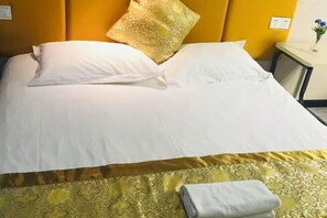 A neatly made bed with white linens and a patterned bedspread, a single decorative pillow, and a folded towel on the side. - 100 Inn (Wuhan Optics Valley Geoscience University) (Wuhan)