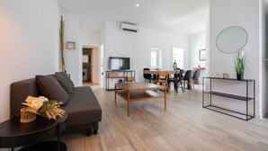 Una sala de estar moderna con sofá, mesa de centro y comedor.