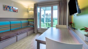 A modern kitchen with a long dining table, a built-in bench with striped cushions, and a large window with curtains. - AR MOR 603 - One Bedroom Apartment, Sleeps 4 (Courseulles-sur-Mer)