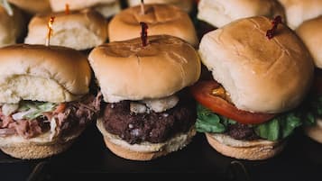 A row of sandwiches with buns, some with toothpicks.