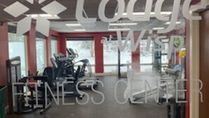 Un gimnasio con equipo de ejercicio y un letrero que dice "The Lodge Fitness Center".