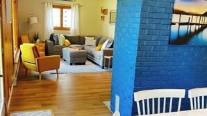 Un salon confortable avec un canapé, des fauteuils et une table à manger.