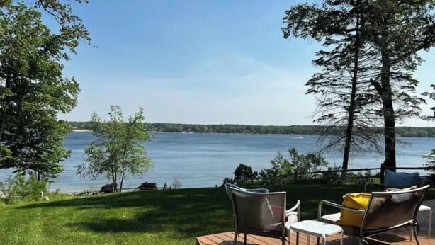 Une terrasse dotée de mobilier d’extérieur, donnant sur un lac.