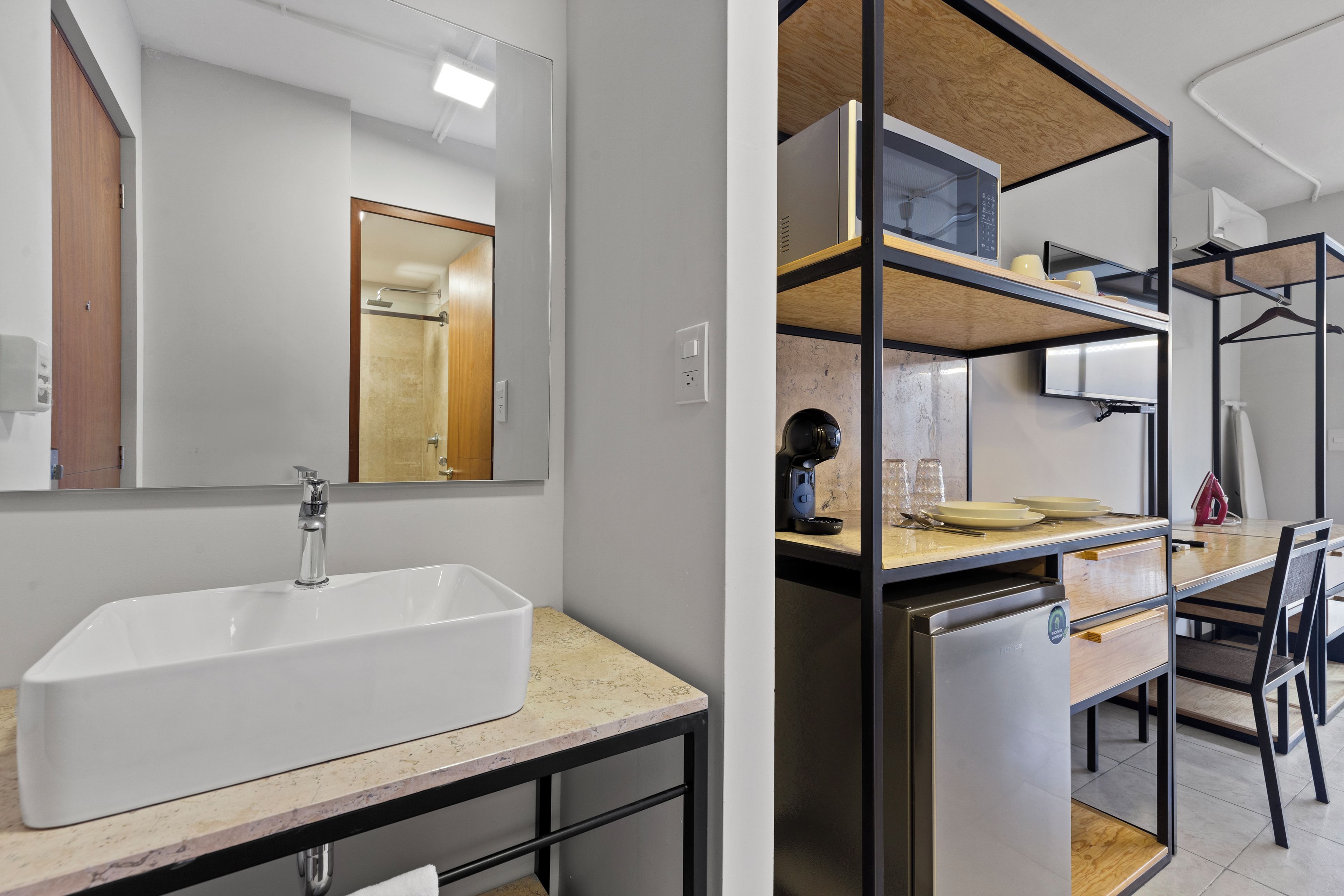 A modern bathroom with a large sink, mirror, and shower.