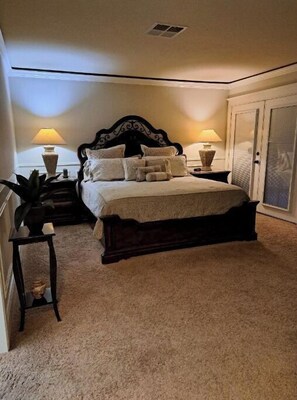 Classic bedroom with a large bed, bedside tables, and a spacious wardrobe.