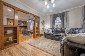 Relax in this inviting living room with a comfortable sofa, bookshelf, and dining area.
