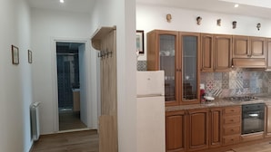 Een moderne keuken met houten kastjes, een ingebouwde oven en een betegelde spatwand.