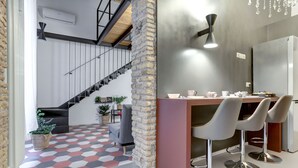 Una cocina moderna con comedor, una escalera y una pared decorativa.
