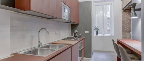 A modern kitchen with stainless steel appliances, wooden cabinets, and a bar area with bar stools.