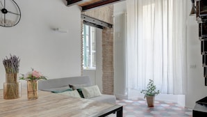 Una sala de estar moderna con un sofá, una mesa de centro de madera y una planta en maceta.