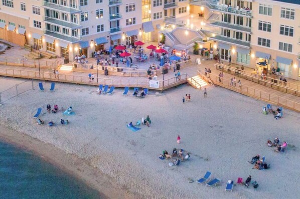 Un hotel sulla spiaggia con zone relax all'aperto, piscina e terrazza coperta.