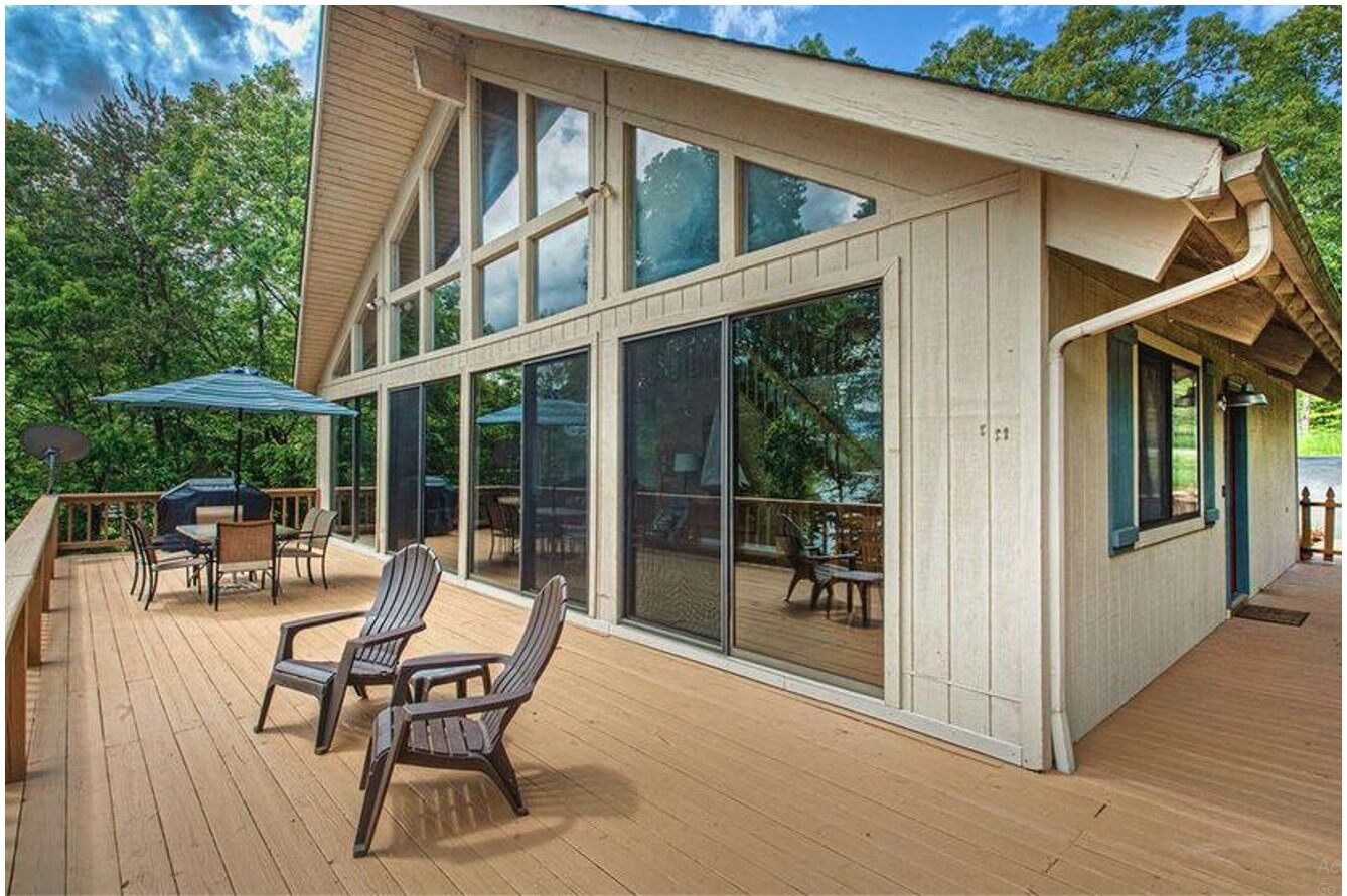 Une maison moderne dotée d’une grande terrasse, de larges fenêtres et de mobilier d’extérieur.