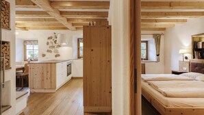 A wooden interior with a kitchen, a dining area, and a bedroom. - Centrally located, family-friendly apartment in the middle of the Dolomites (Sankt Ulrich)