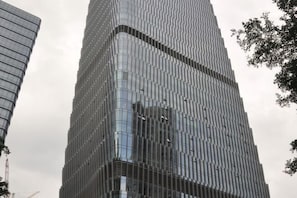 A tall, modern skyscraper with a grid-like facade and reflective glass windows.