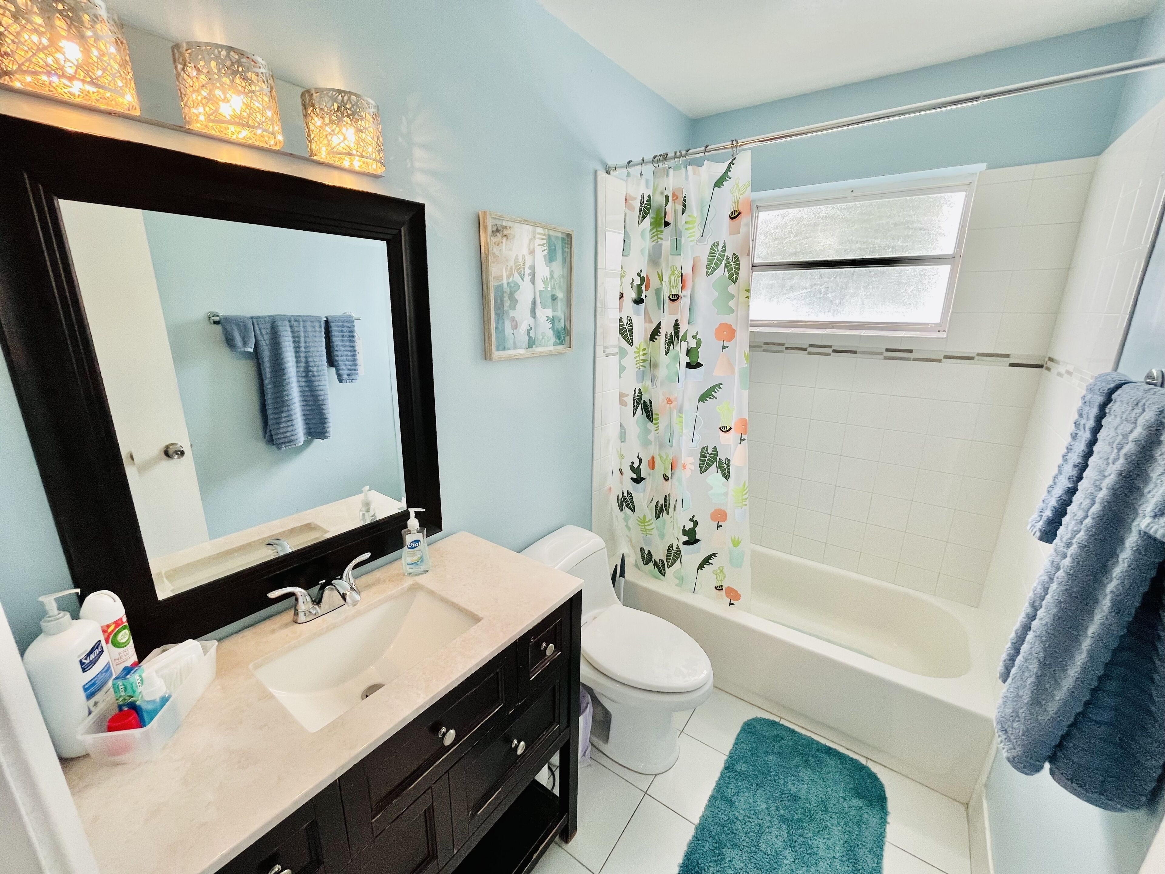 A bathroom with a sink, mirror, toilet, and bathtub.
