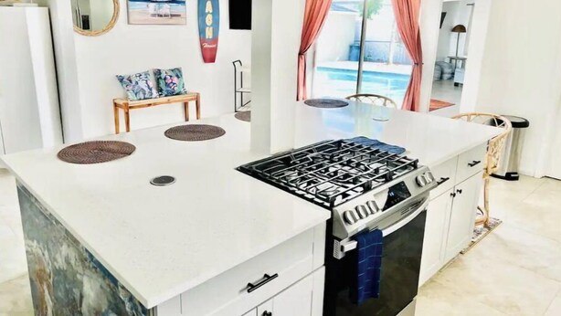 A modern kitchen with a central island, a gas stove, and a built-in oven. - Fun Kids Family Stay - FLL Cruise Guests & Airport! AirHockey-Arcade-Pool-Toys (Hollywood)