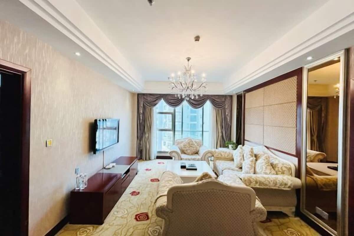 Een hotelkamer met een groot bed, een bank, een televisie en een eettafel.