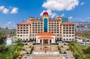 Un hotel grande con varios pisos, un patio central y una cúpula roja en la parte superior.