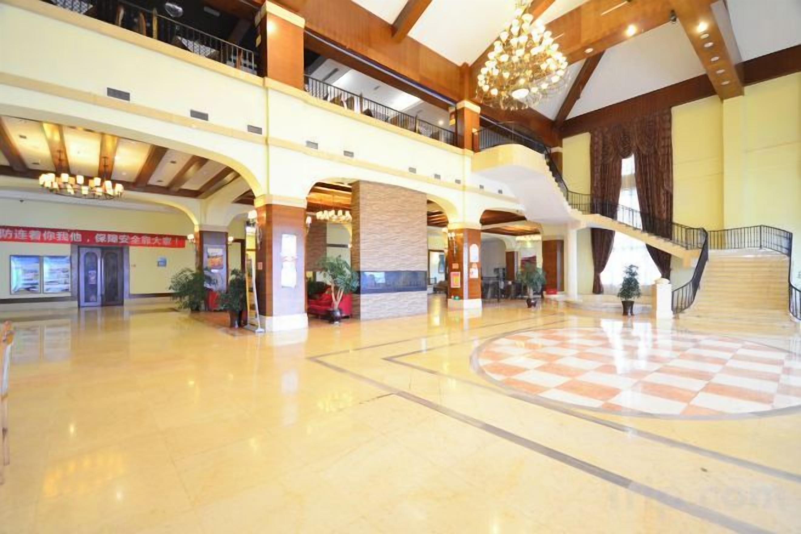 A spacious indoor area with a central open space, multiple levels with balconies, and a staircase leading to an upper floor.