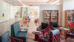 A modern library with seating areas, bookshelves, and a glass partition. - Kojima Lilac Apartament, Praia da Rocha, Portimao (Portimão)