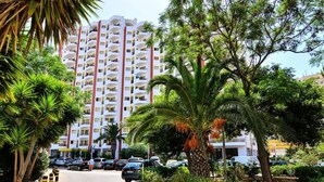 A multi-story hotel with balconies, surrounded by lush greenery and parked cars. - Kojima Lilac Apartament, Praia da Rocha, Portimao (Portimão)