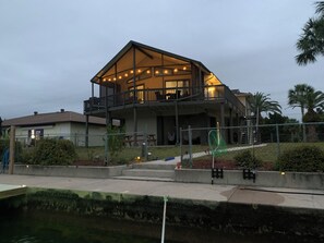A two-story house with a balcony, a covered patio, and a pool area. - Waterfront Retreat-Private Dock-Gulf Access-Kayaks-Boat Trailer Parking (Hernando Beach)