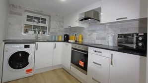 Cocina compacta con lavadora, horno y microondas integrados.
