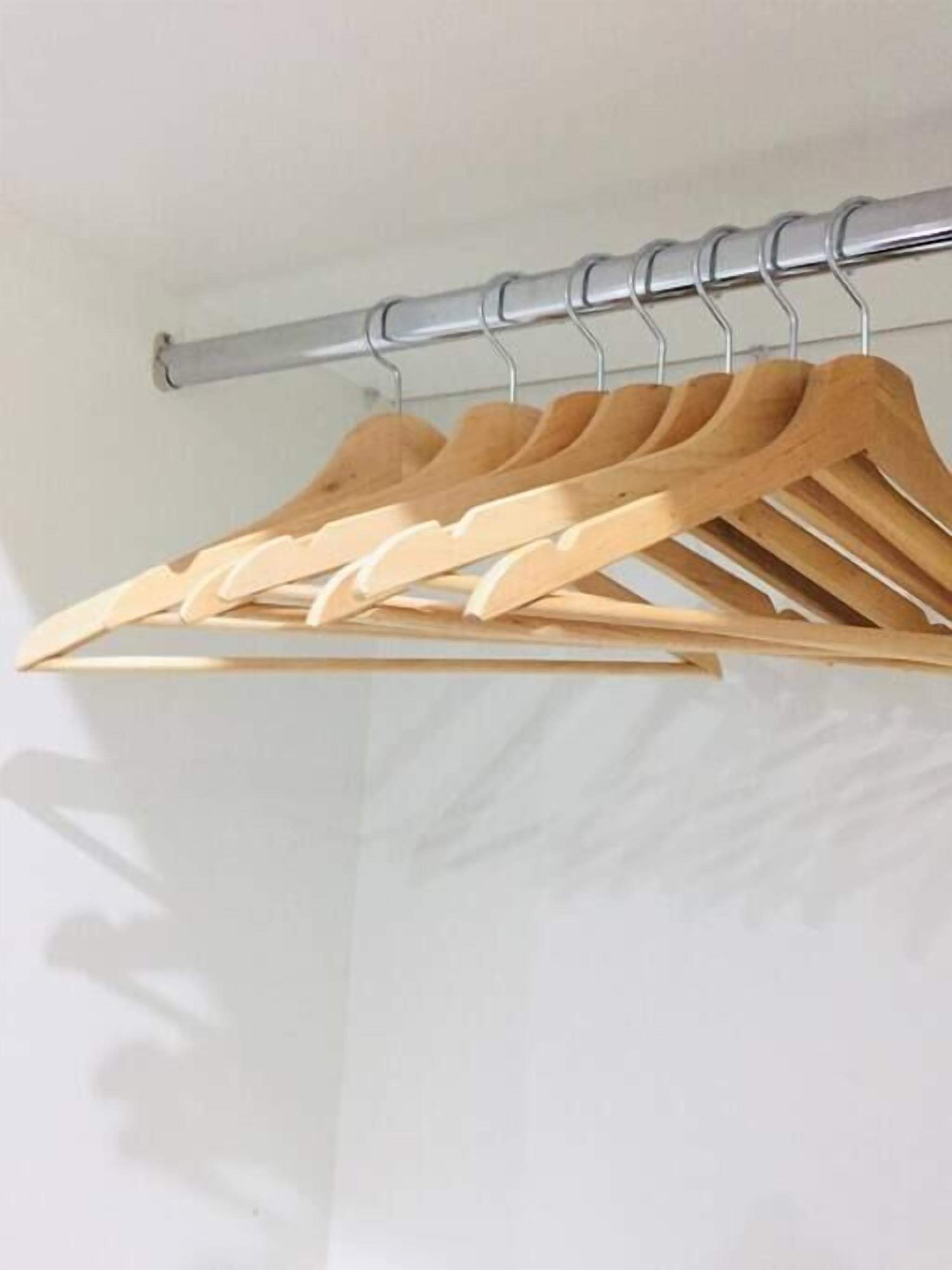 A metal curtain rod with wooden hangers.