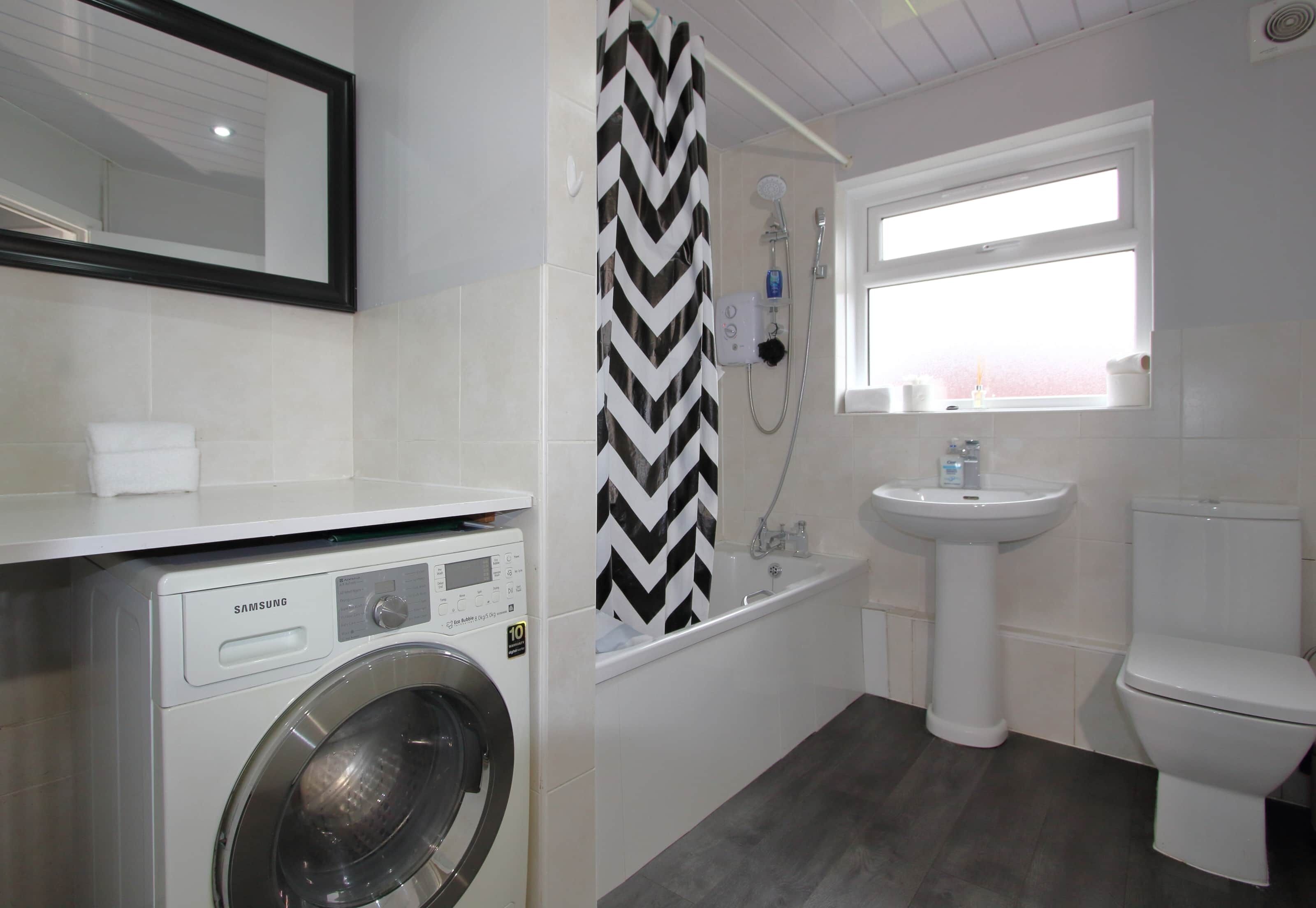 Bathtub, hair dryer, towels, shampoo