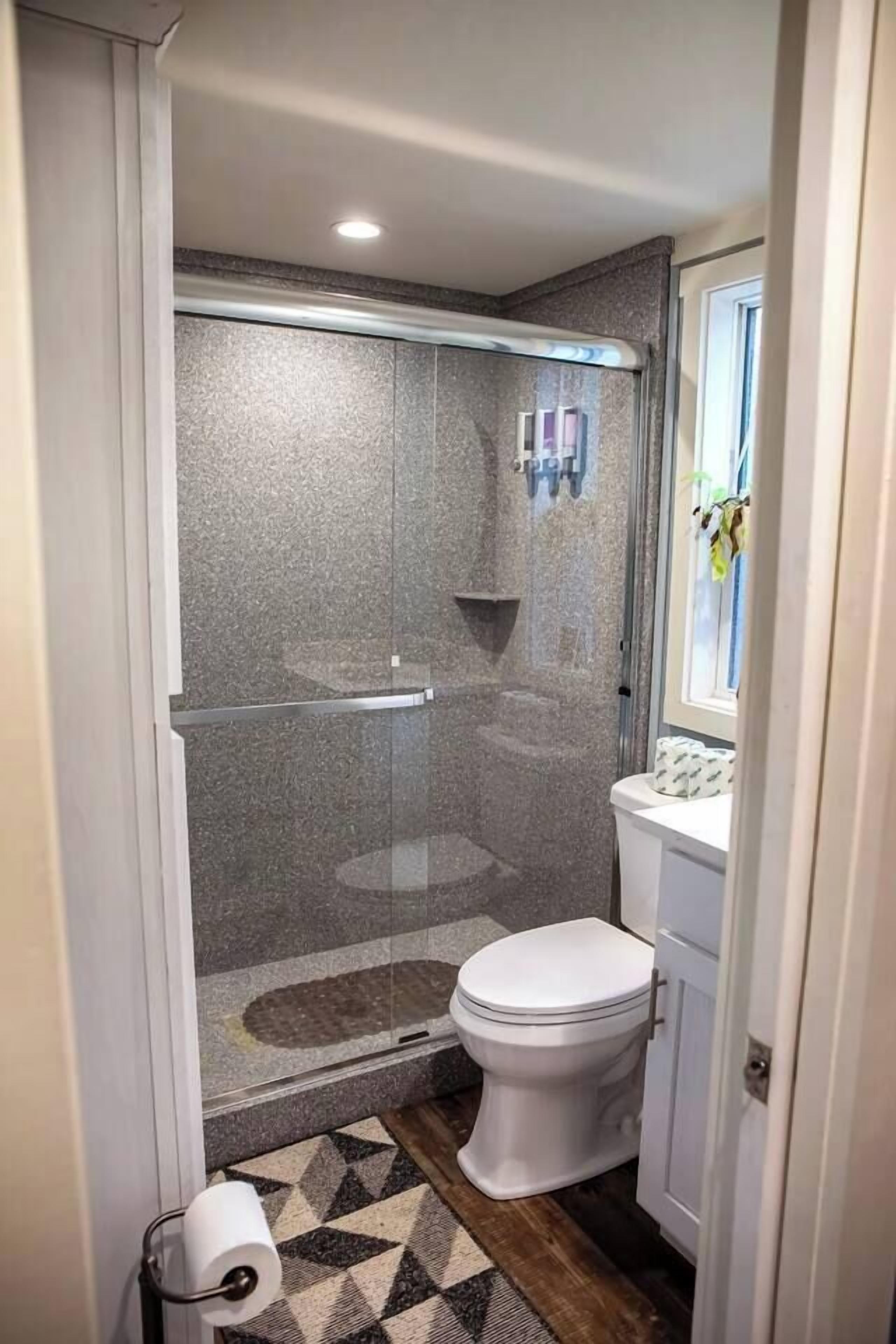 Ein Badezimmer mit Dusche, Toilette und Waschbecken.