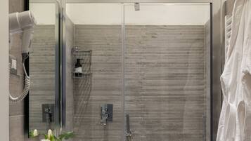 A modern bathroom with a glass-enclosed shower, a vanity with a mirror, and a toilet.