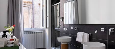 A modern bathroom with two sinks, a large mirror, and a shower area.