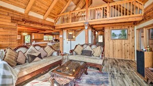 A spacious log cabin interior with a high ceiling, wooden furniture, and a balcony overlooking the landscape. - Stunning Cabin with Great Views and blissful sunsets! (Sonora)